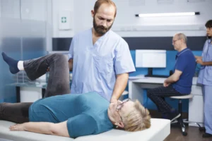 chiropractor helping old woman with knee pain